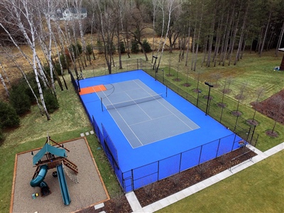  Outdoor residential sports court with a blue surface and orange accent, featuring a tennis net in Colombus.