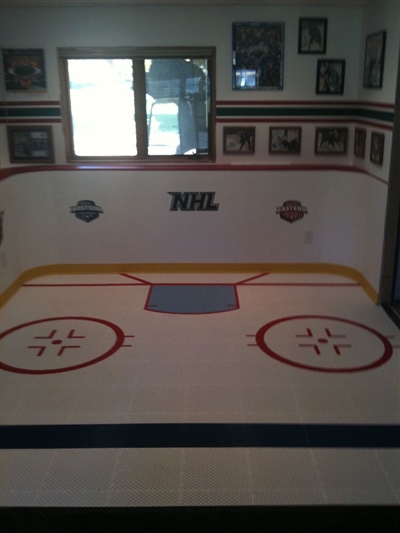  An indoor hockey practice area featuring painted goal creases the NHL logo.