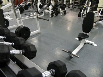 Indoor workout room with grey flooring and multiple workout equipment in Nininger.