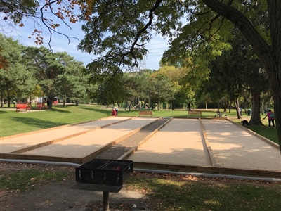 Multiple bocce ball courts surrounded by trees and greenery. 