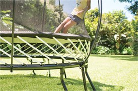 Black trampoline with a black safety net and yellow spring layer in Hastings.