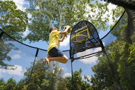 Black trampoline with a black safety net and black basketball hoop.