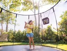 Black trampoline with a black safety net in Coates.