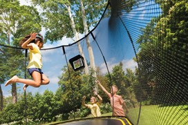 Black trampoline with a black safety net and yellow trim.