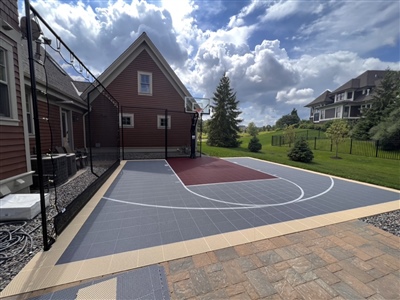  The court features a bright blue playing area with contrasting red and yellow lines marking the boundaries and key areas. The center circle is distinctly highlighted, and the overall design is vibrant, making the court visually appealing and suitabl